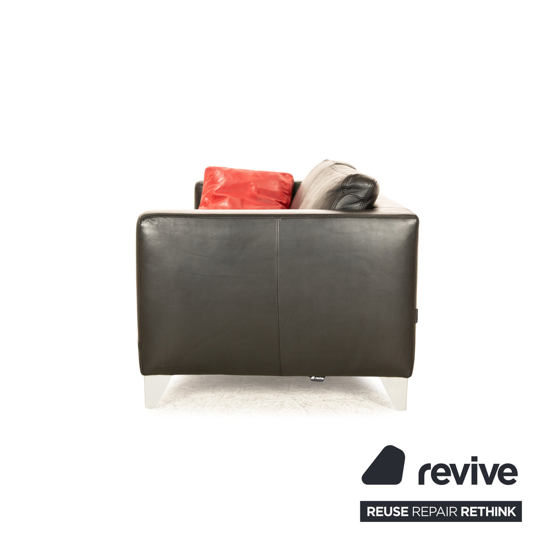 Canapé trois places en cuir noir Machalke avec coussin rouge