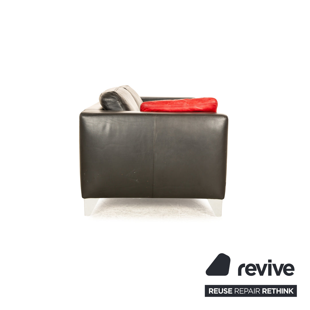 Canapé trois places en cuir noir Machalke avec coussin rouge
