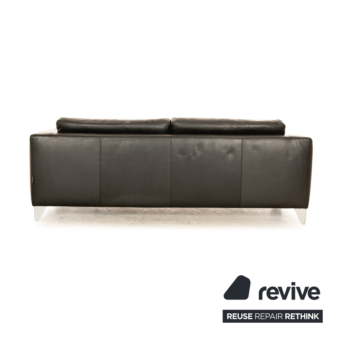 Canapé trois places en cuir noir Machalke avec coussin rouge