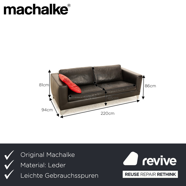 Canapé trois places en cuir noir Machalke avec coussin rouge