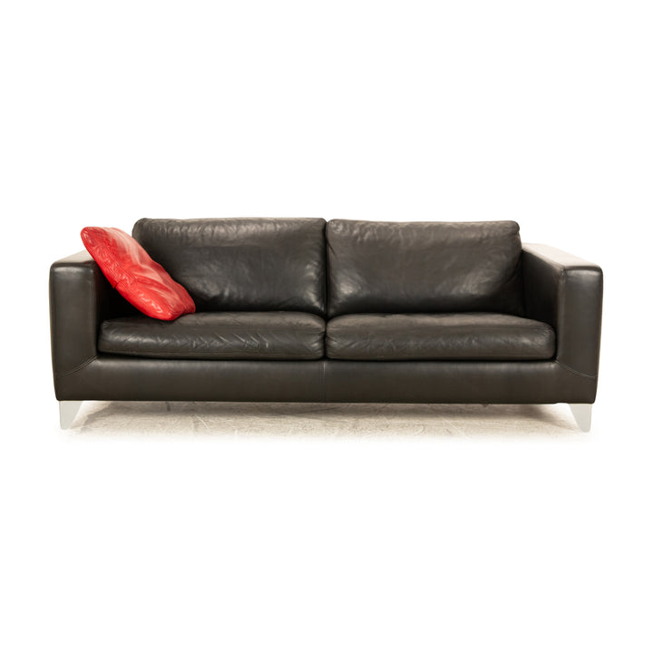 Canapé trois places en cuir noir Machalke avec coussin rouge