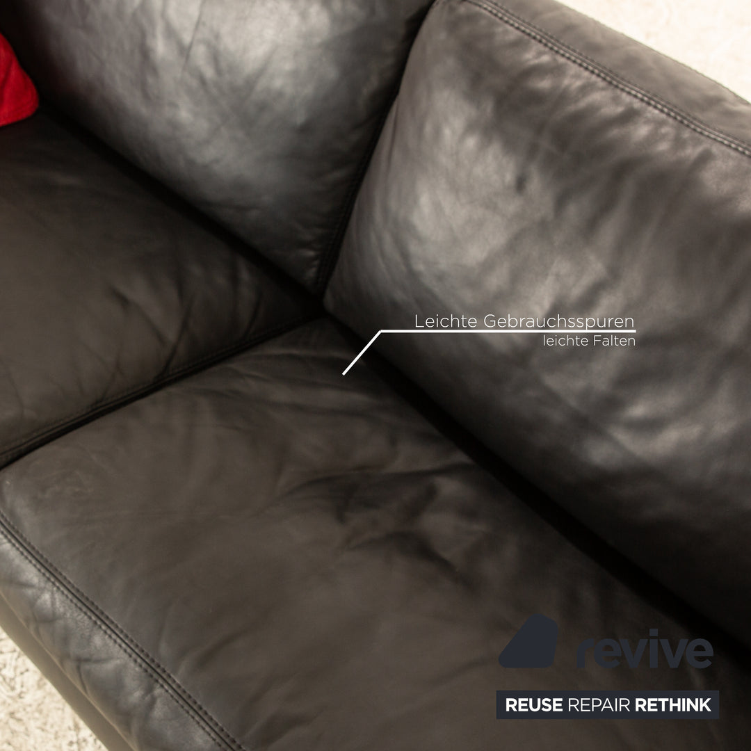 Canapé trois places en cuir noir Machalke avec coussin rouge