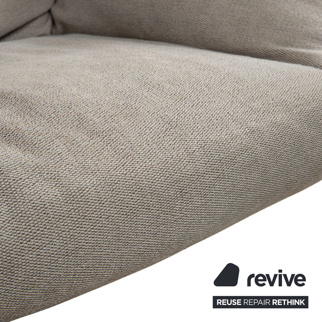 Fauteuil lounge COR Cordia avec repose-pieds, revêtement en cuir marron et tissu beige.