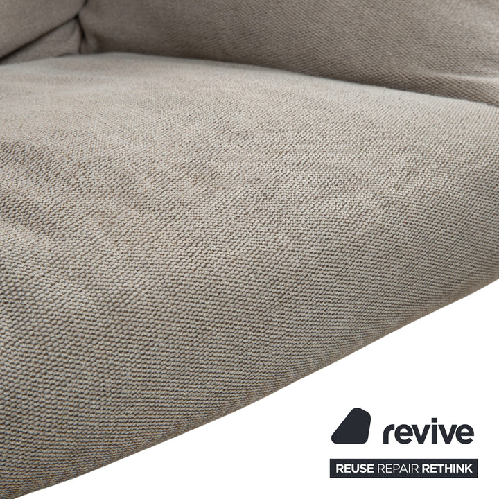 Fauteuil lounge COR Cordia avec repose-pieds, revêtement en cuir marron et tissu beige.