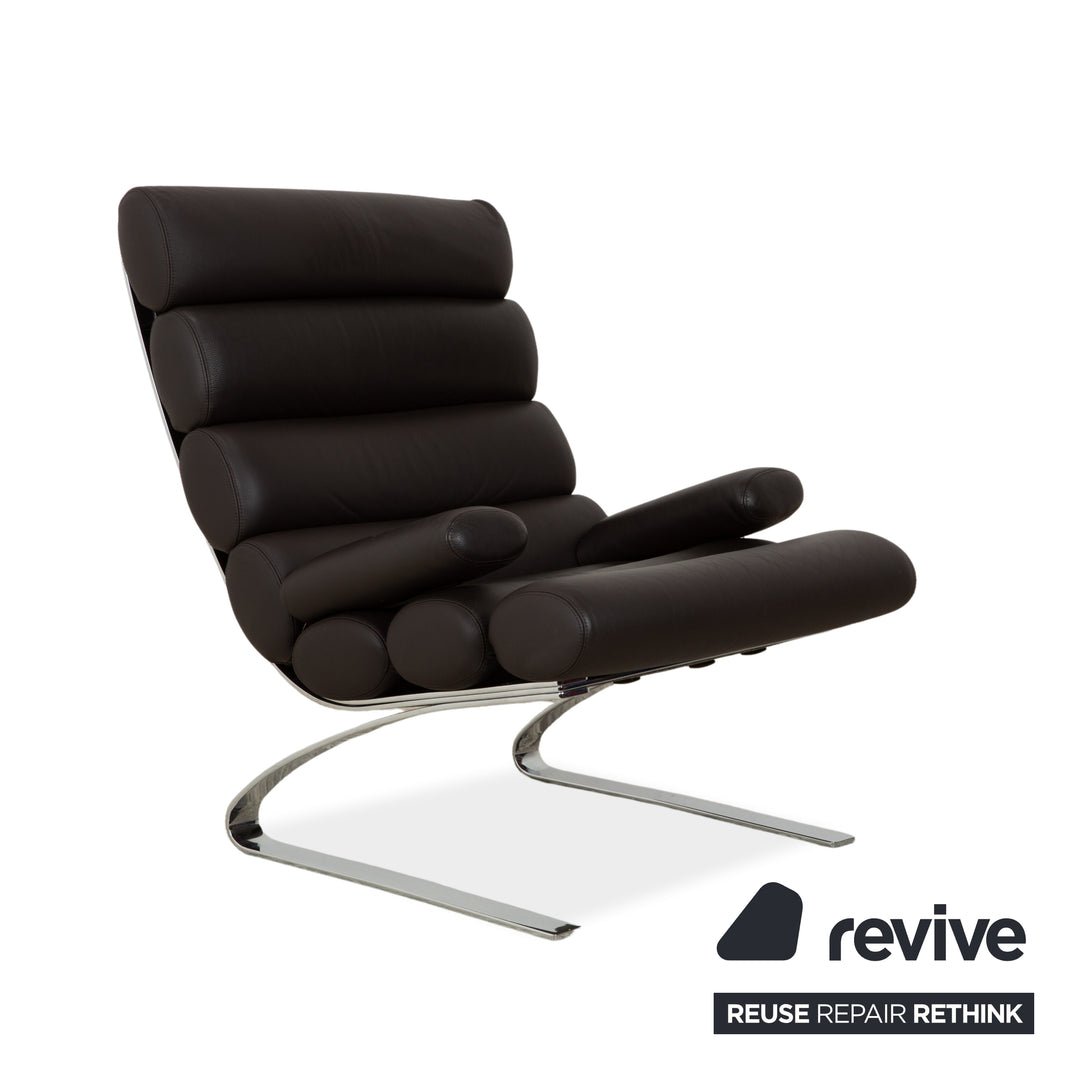Fauteuil COR Sinus en cuir chromé marron avec accoudoirs et repose-pieds inclus.